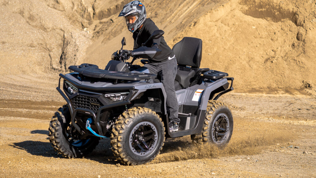 SPORTIVA 620 GT im Offroad-Einsatz mit Fahrer in Action, spritzender Schotter, kraftvoller Drift auf losem Untergrund.